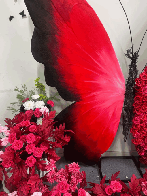 Artificial Rose-Accented Butterfly Backdrop with Gradient Red and Black Theme