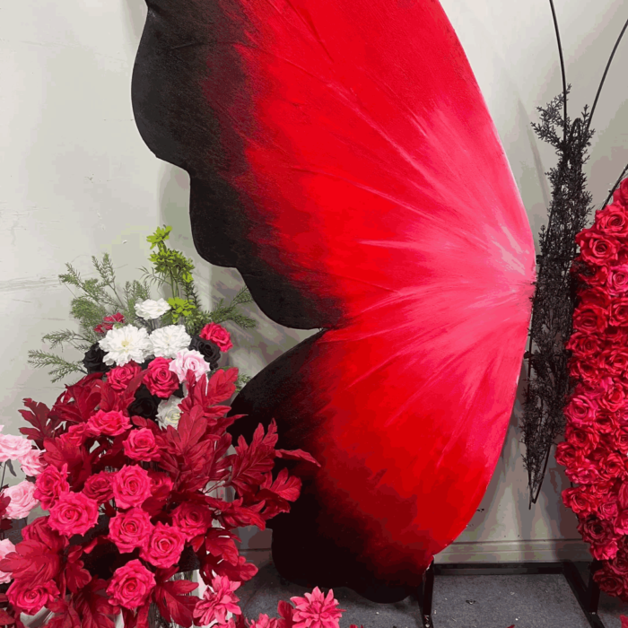 Artificial Rose-Accented Butterfly Backdrop with Gradient Red and Black Theme
