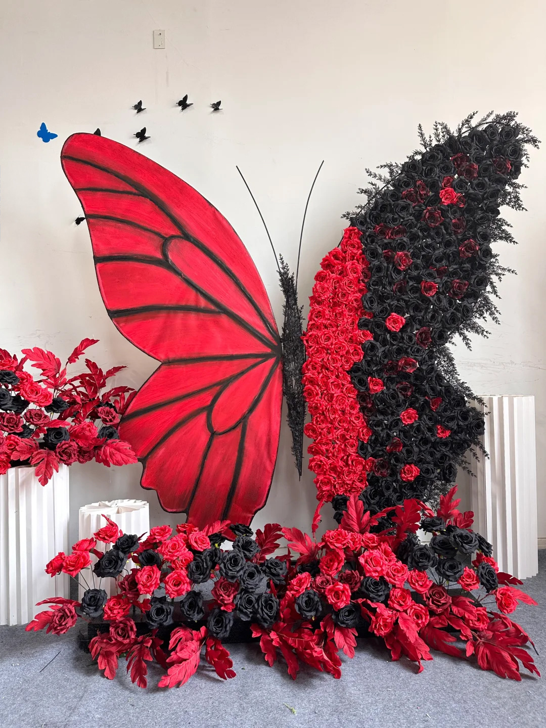 Artistic Red and Black Butterfly Backdrop with Lush Rose Arrangements