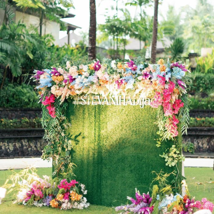 Bohemian Rainbow Garden Wedding in Bali: Square Green Wall & Colorful Floral Topper