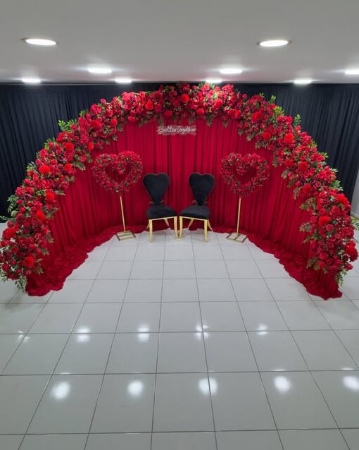 Create a Stunning Henna Party with a Red Rose Arch and Silk Curtain Backdrop