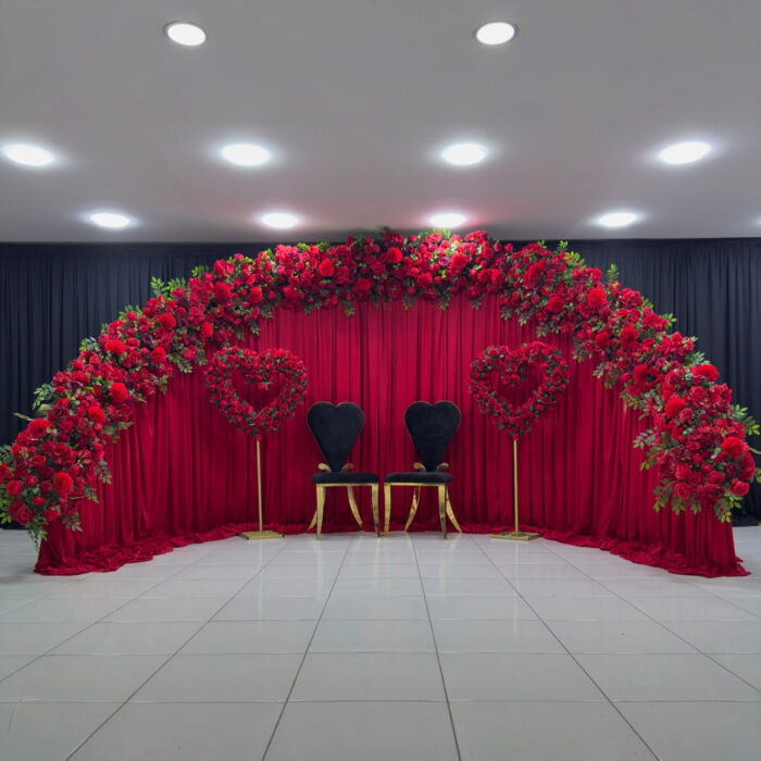 Create a Stunning Henna Party with a Red Rose Arch and Silk Curtain Backdrop