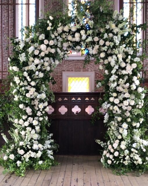 Elegant White and Green Wedding Arch with Floral Accents for a Timeless Celebration
