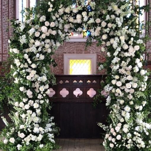 Elegant White and Green Wedding Arch with Floral Accents for a Timeless Celebration
