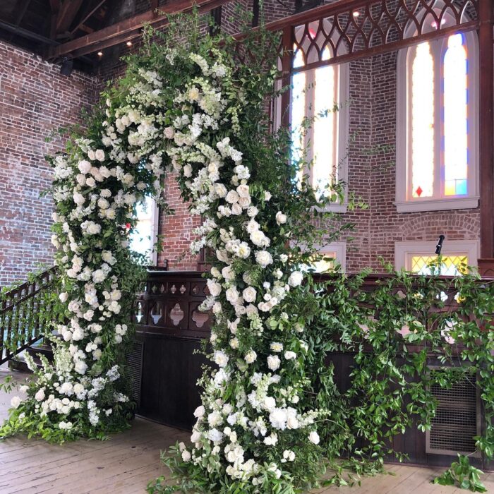 Elegant White and Green Wedding Arch with Floral Accents for a Timeless Celebration