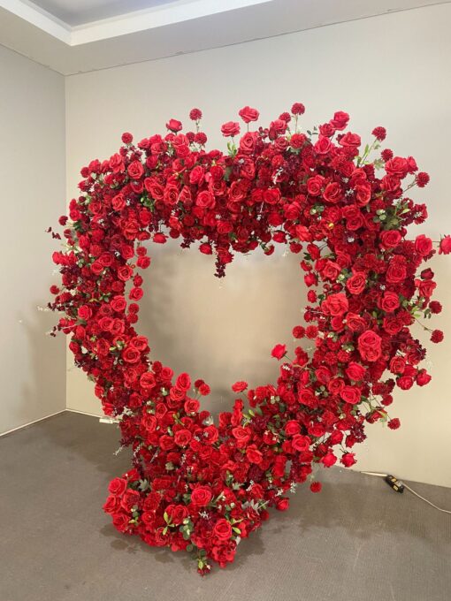 Luxurious Heart-Shaped Arch with Bold Red Roses and Greenery for a Majestic Wedding Backdrop