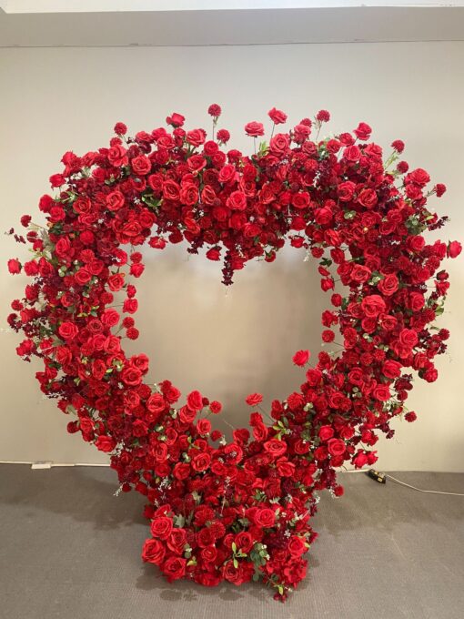 Luxurious Heart-Shaped Arch with Bold Red Roses and Greenery for a Majestic Wedding Backdrop