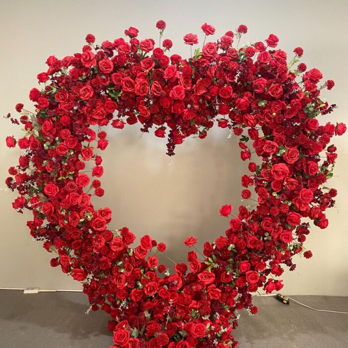 Luxurious Heart-Shaped Arch with Bold Red Roses and Greenery for a Majestic Wedding Backdrop