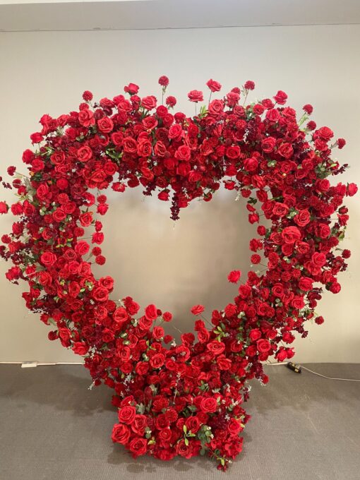 Luxurious Heart-Shaped Arch with Bold Red Roses and Greenery for a Majestic Wedding Backdrop