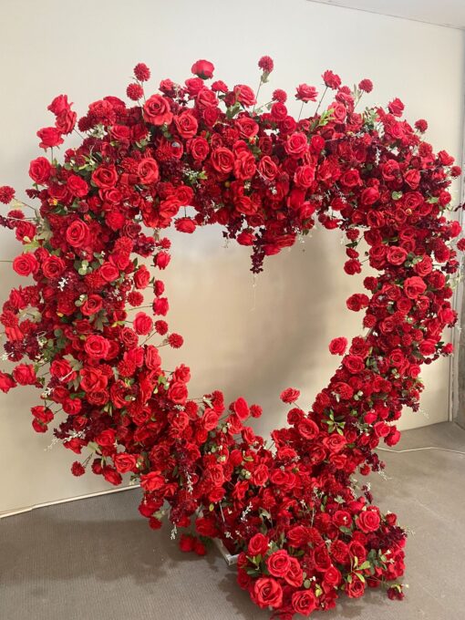 Luxurious Heart-Shaped Arch with Bold Red Roses and Greenery for a Majestic Wedding Backdrop