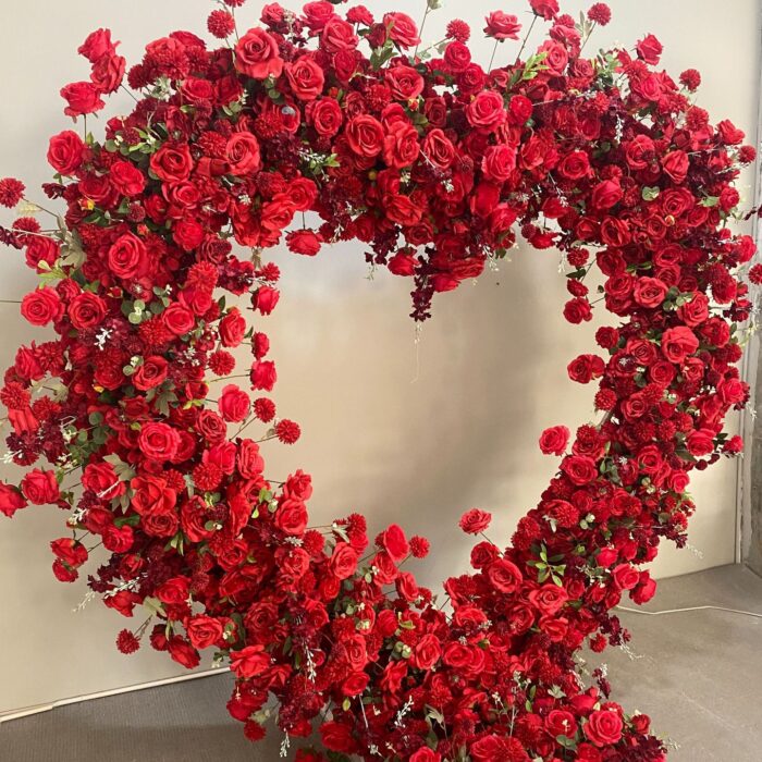 Luxurious Heart-Shaped Arch with Bold Red Roses and Greenery for a Majestic Wedding Backdrop