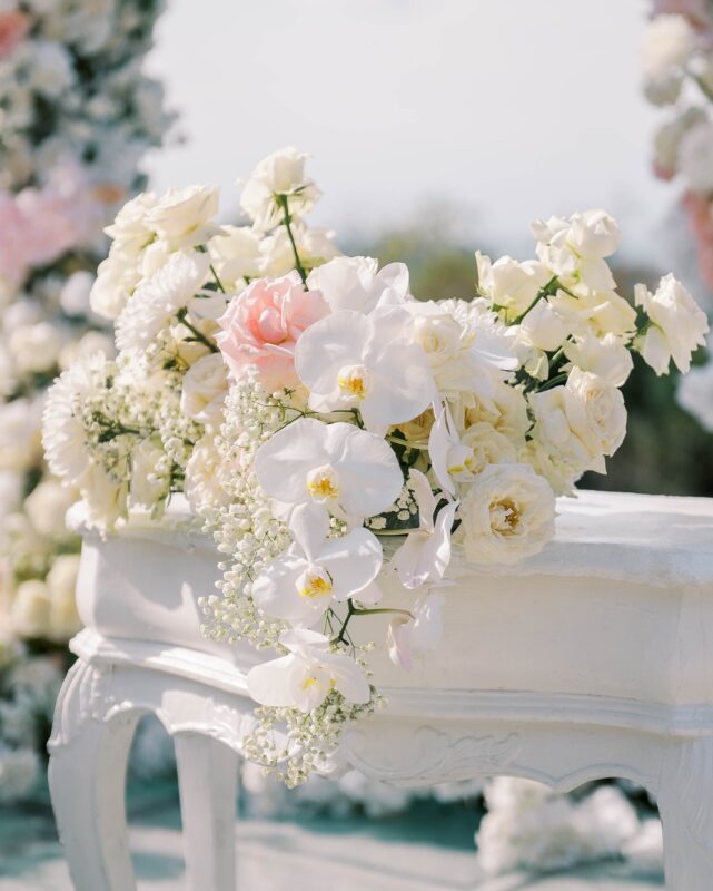 Romantic Seaside Ceremony Setup with Intertwined Floral Arches for an Elegant Celebration