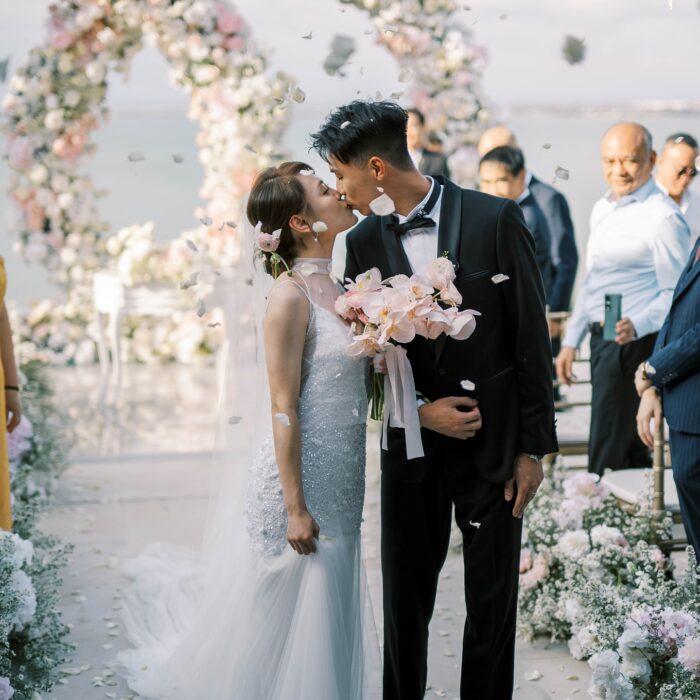 Romantic Seaside Ceremony Setup with Intertwined Floral Arches for an Elegant Celebration