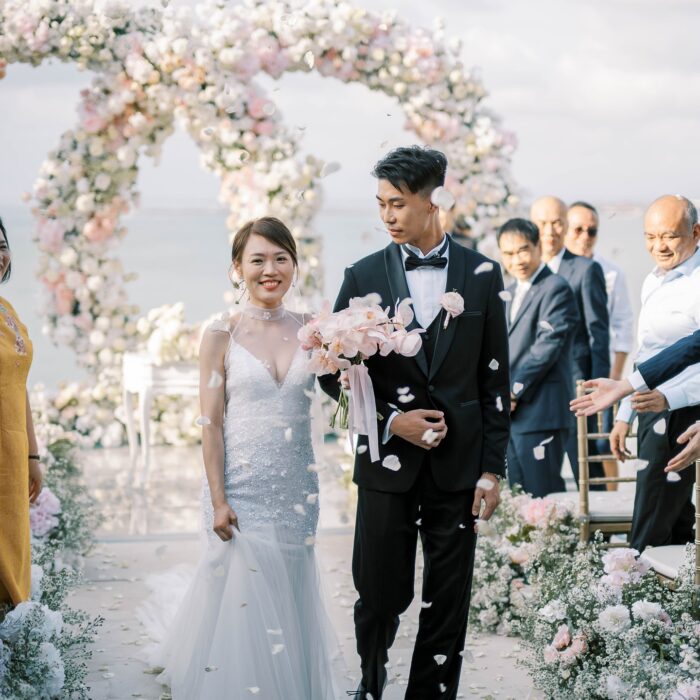 Romantic Seaside Ceremony Setup with Intertwined Floral Arches for an Elegant Celebration