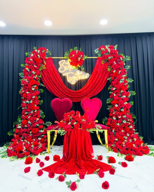 Romantic Wedding Arch with Red Roses, Green Leaves, and Elegant Drapery