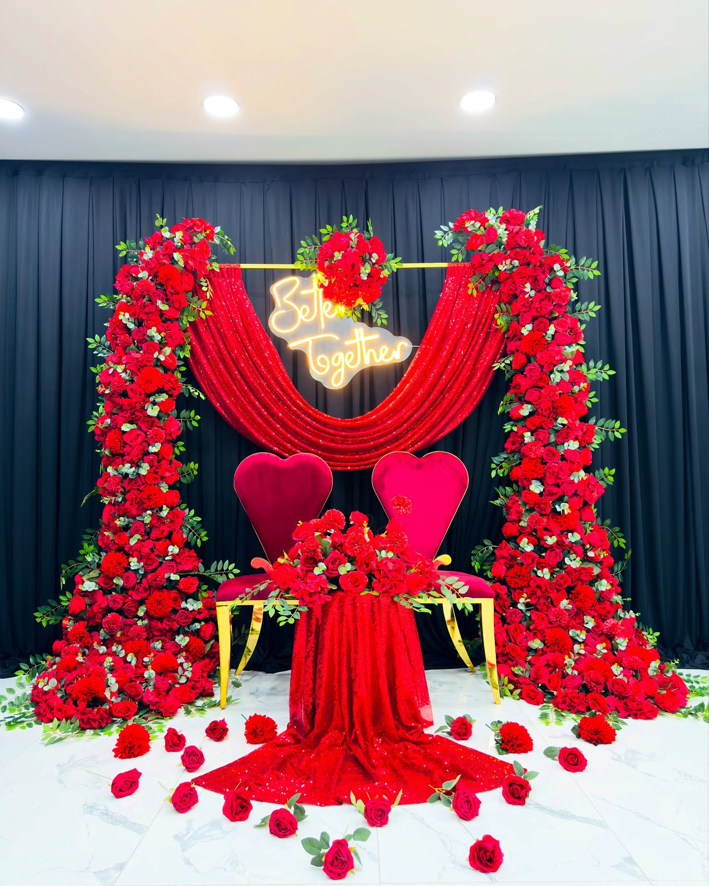 Romantic Wedding Arch with Red Roses, Green Leaves, and Elegant Drapery