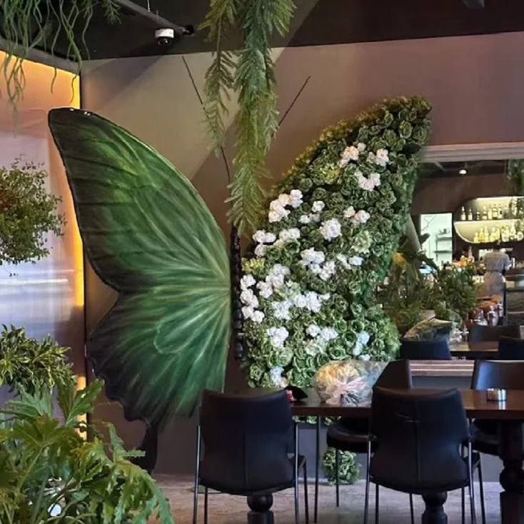 Sophisticated Green Butterfly Backdrop with White Artificial Floral Arrangements for Events