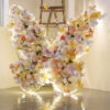 Sophisticated Warm Tone Butterfly Backdrop with Artificial Flowers and LED Elements